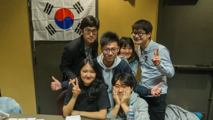 Group of international students smiling for the camera and giving the peace sign