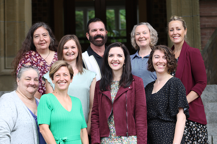 A group of 9 Career Services Center staff standing on the front stairs of Old Main.