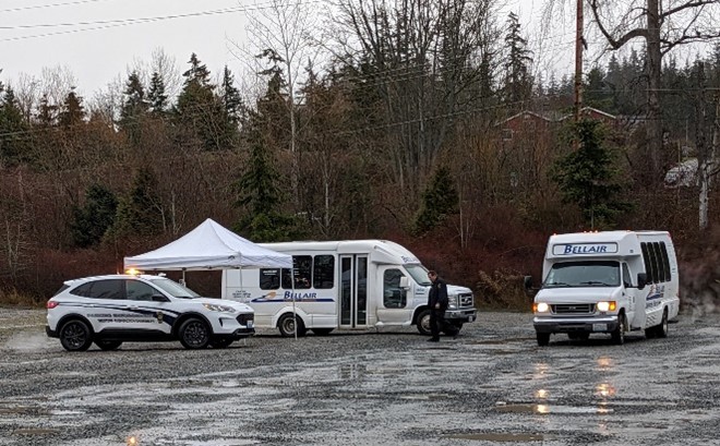 White tent, WWU parking enforcement vehicle and two Bell-Air shuttle buses parked in Lincoln Creek parking are on a very wet day